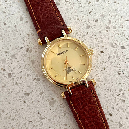 Burberrys Gold Lady Watch with Sculpted Loop Lugs and Champagne Dial 24mm Diameter