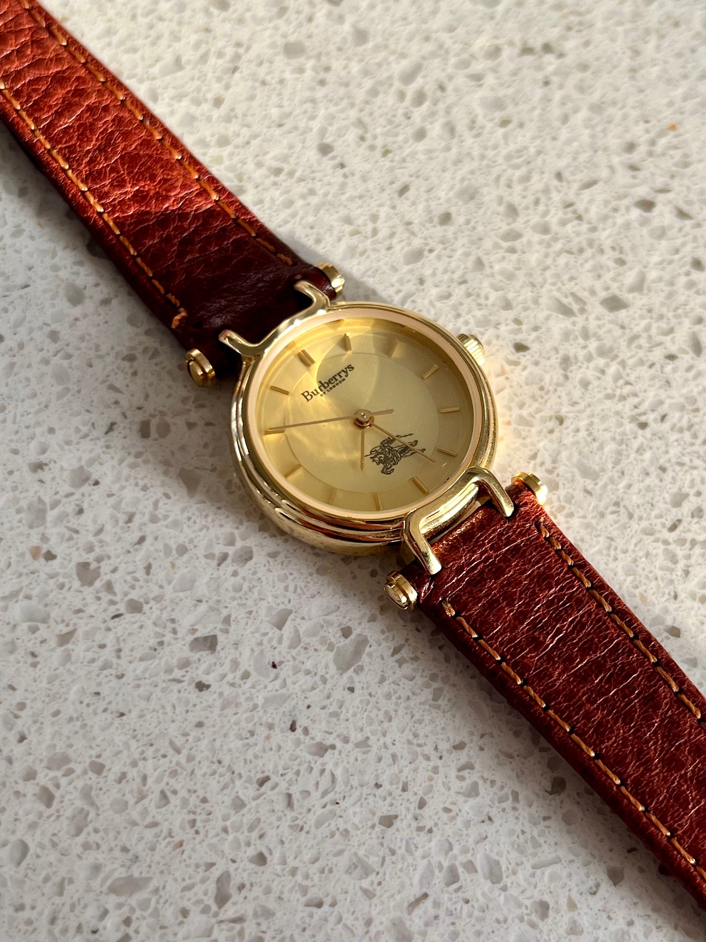 Burberrys Gold Lady Watch with Sculpted Loop Lugs and Champagne Dial 24mm Diameter