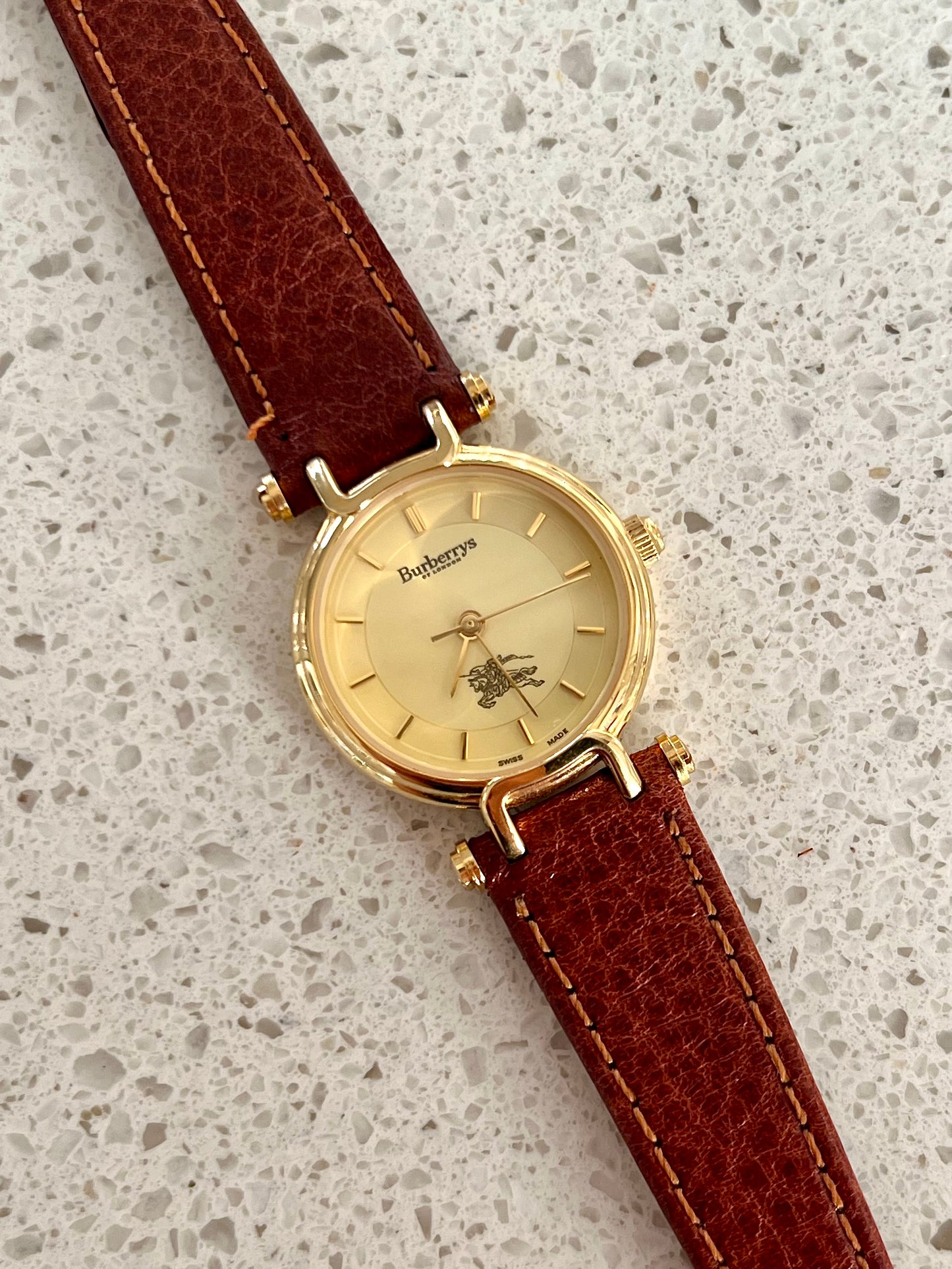 Burberrys Gold Lady Watch with Sculpted Loop Lugs and Champagne Dial 24mm Diameter