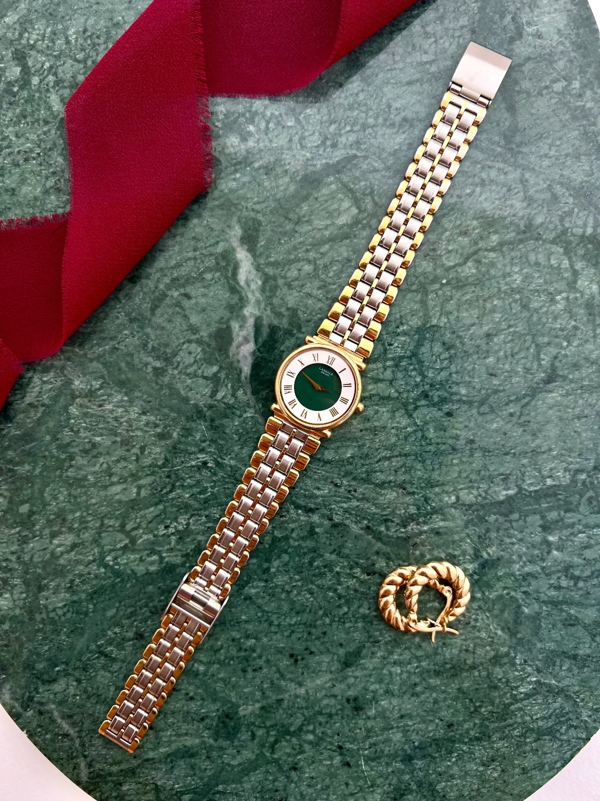 Luxurious Gold women's watch and earrings on a green marble surface