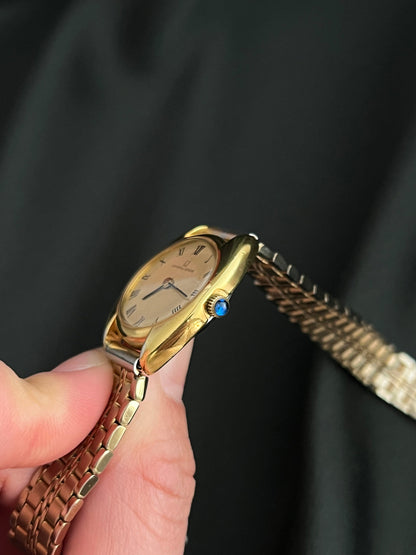 Universal Geneve C Case Roman Dial Gold Watch: case profile and blue crown accent.