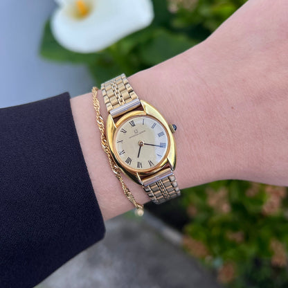 Universal Geneve C Case Roman Dial Gold Watch: roman dial and C case worn on wrist.