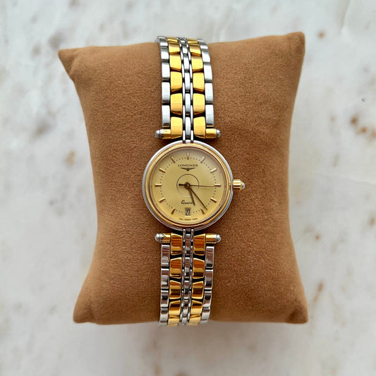 Two-tone Longines Women's watch on a brown cushion with a marble background