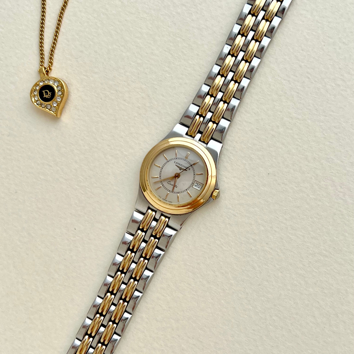 Longines Women's Watch Two-tone watch with gold and silver band on a light beige background