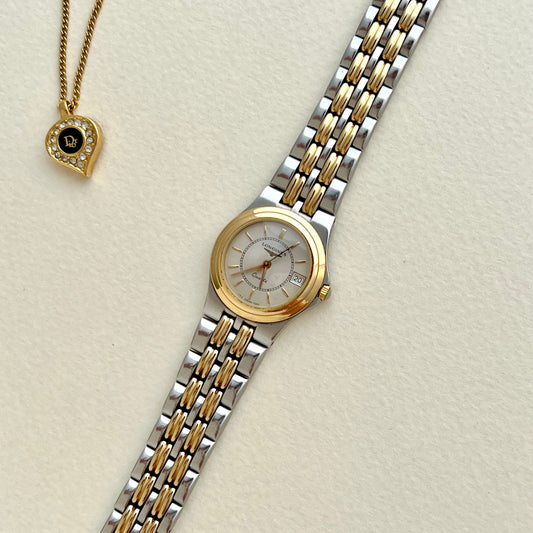 Longines Women's Watch Two-tone watch with gold and silver band on a light beige background