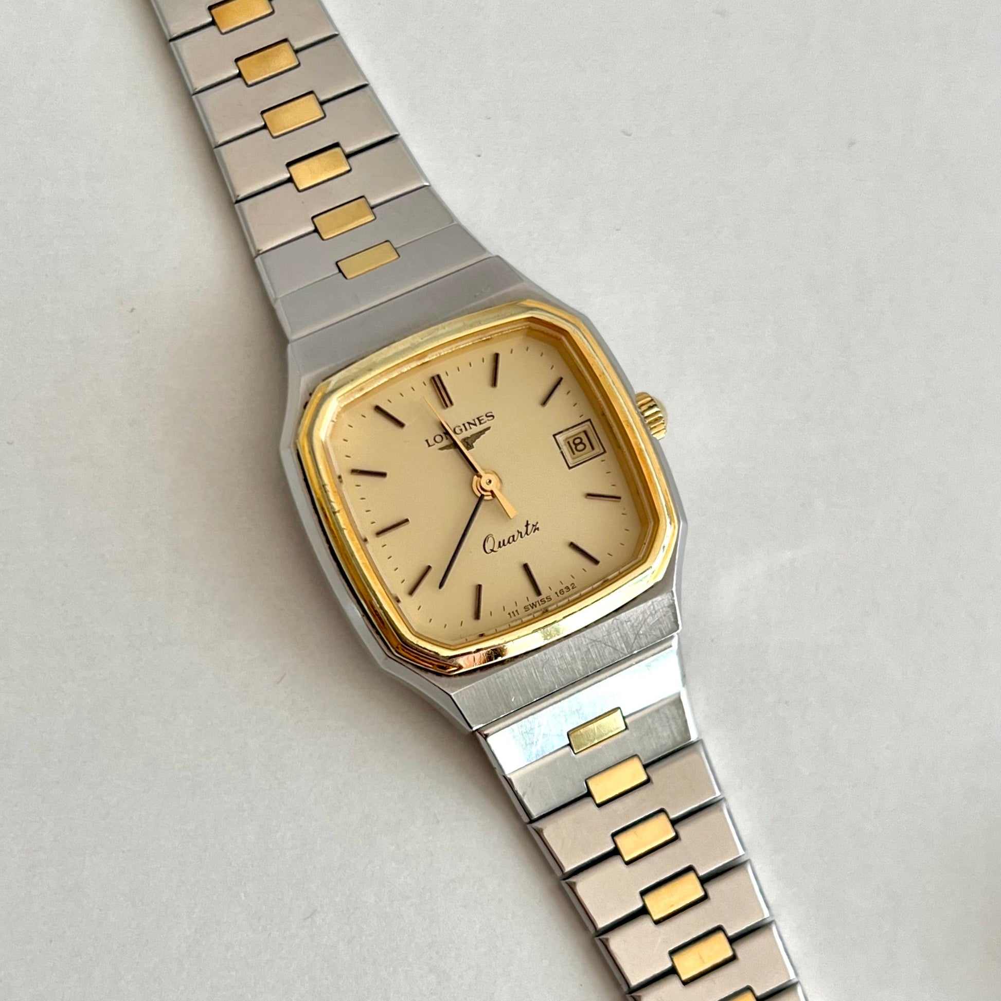 Longines Two-tone watch with gold and silver band on a light gray background