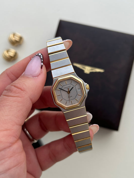 Vintage Longines two tone women's watch featuring an octagonal case, silver textured dial, integrated bracelet and date window at 3 o'clock