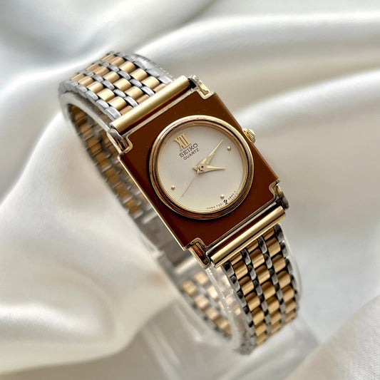 Gold and silver watch on a white satin background