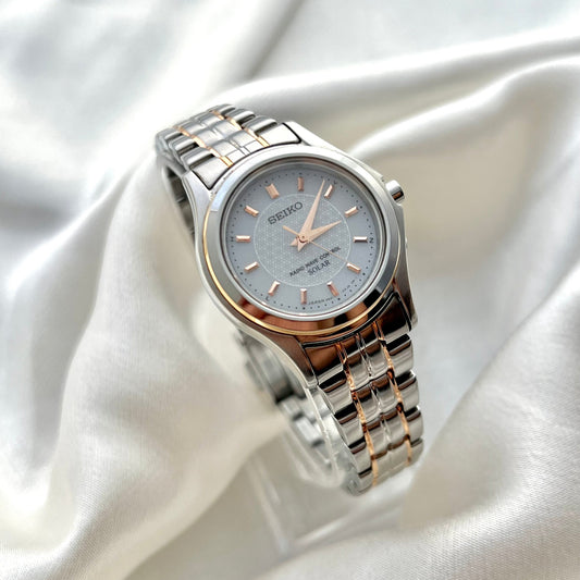 Silver Seiko watch on a white satin background
