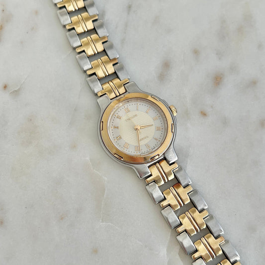 Two-tone watch with silver and gold band on a marble surface