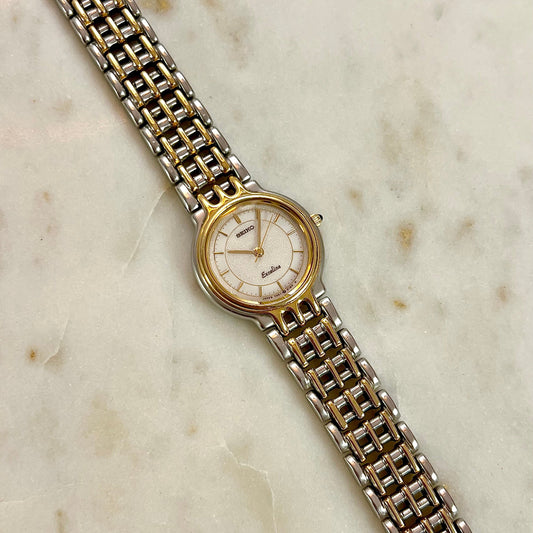 Two-tone Seiko Exceline watch with gold and silver band on a marble surface