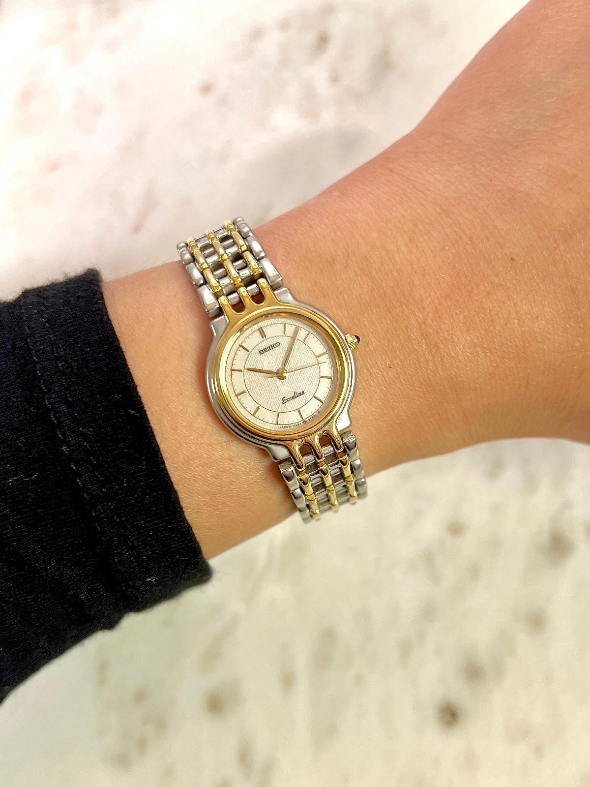 Two-tone Seiko Exceline Women's vintage watch on a wrist with a blurred background