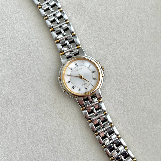 Seiko Exceline Silver watch with a white face on a light gray background and claws