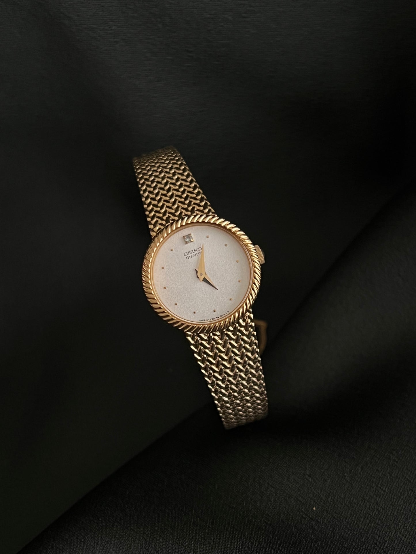 Gold Seiko Watch with a white face on a black background