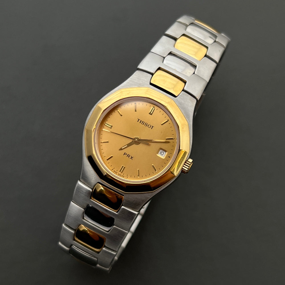 Tissot PRX Ladies Watch Two-tone with gold and silver band on a dark background