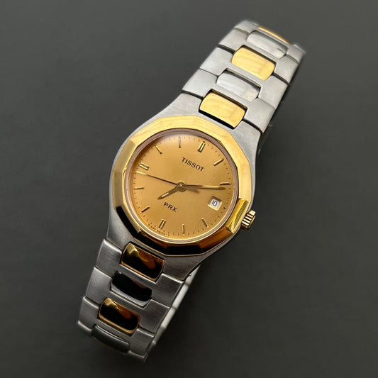 Tissot PRX Ladies Watch Two-tone with gold and silver band on a dark background