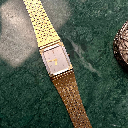 YSL Gold  Luxurious Woman's Watch with a square face on a green marble surface