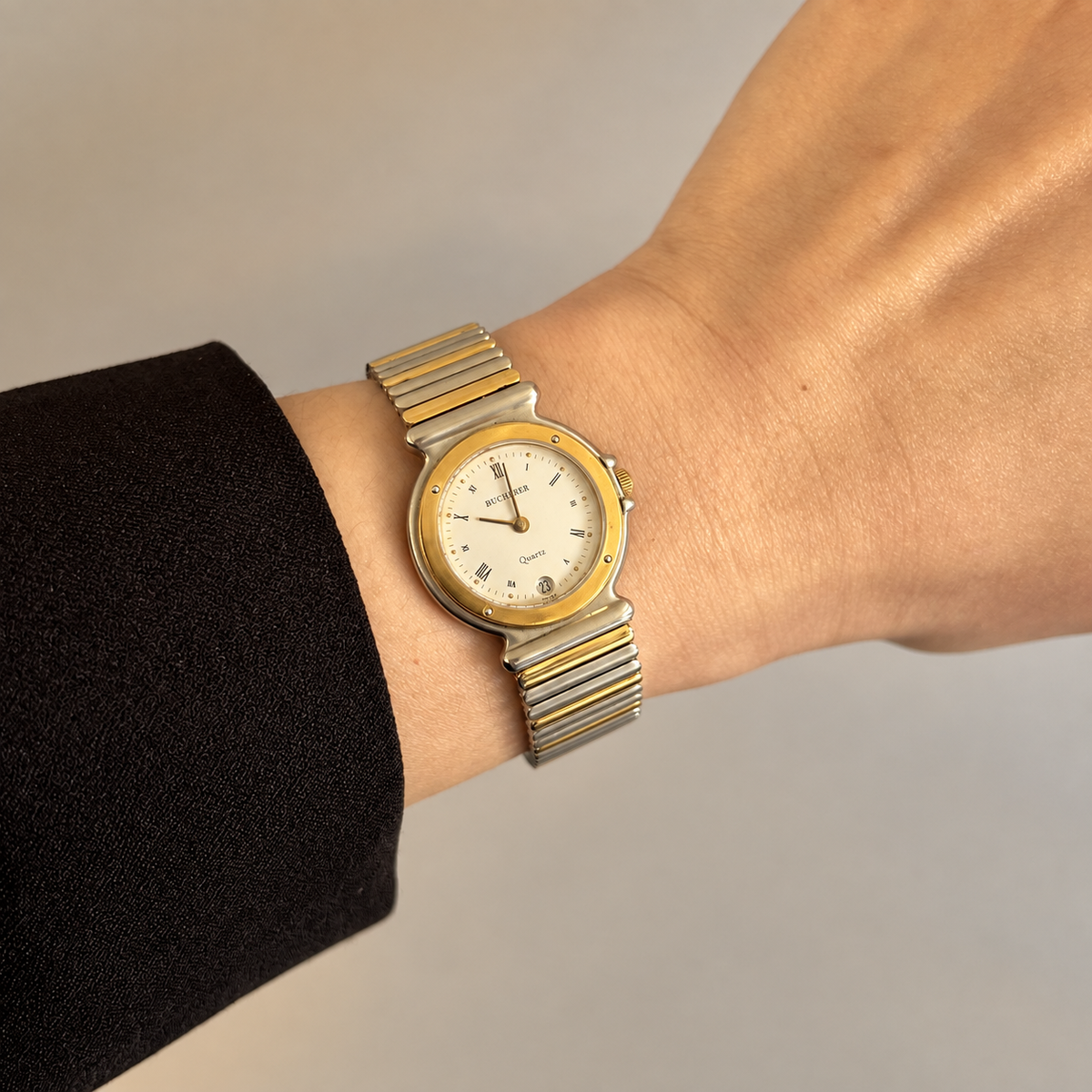 Bucherer two tone Roman numeral date watch worn on wrist in warm golden hour light