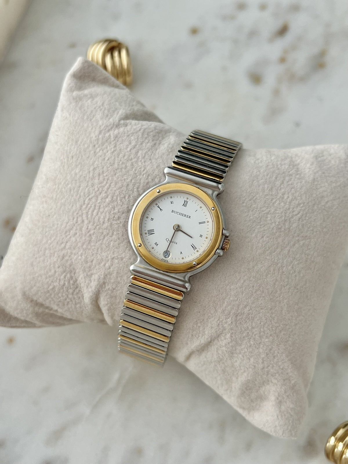 Angled view of Bucherer Classic Quartz Date 256.510 women’s watch with gold tone bezel and two tone bracelet