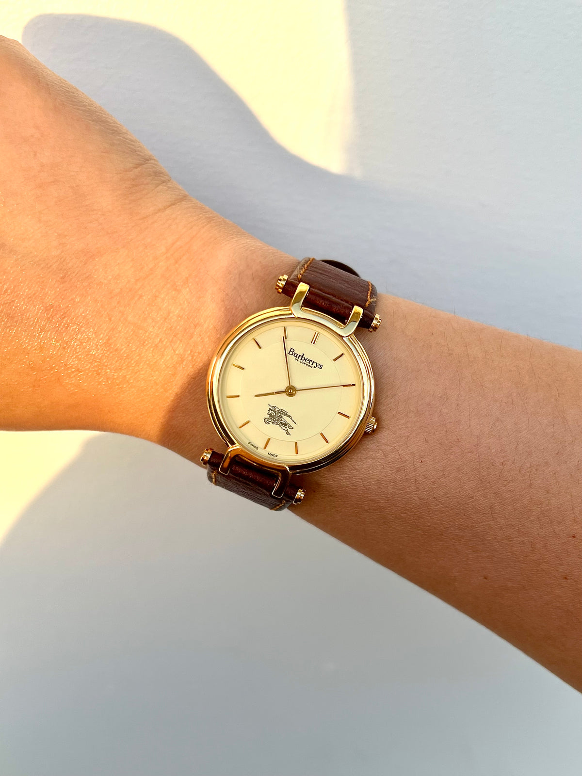 Close-up of the Burberrys champagne dial with gold markers and Equestrian Knight emblem.