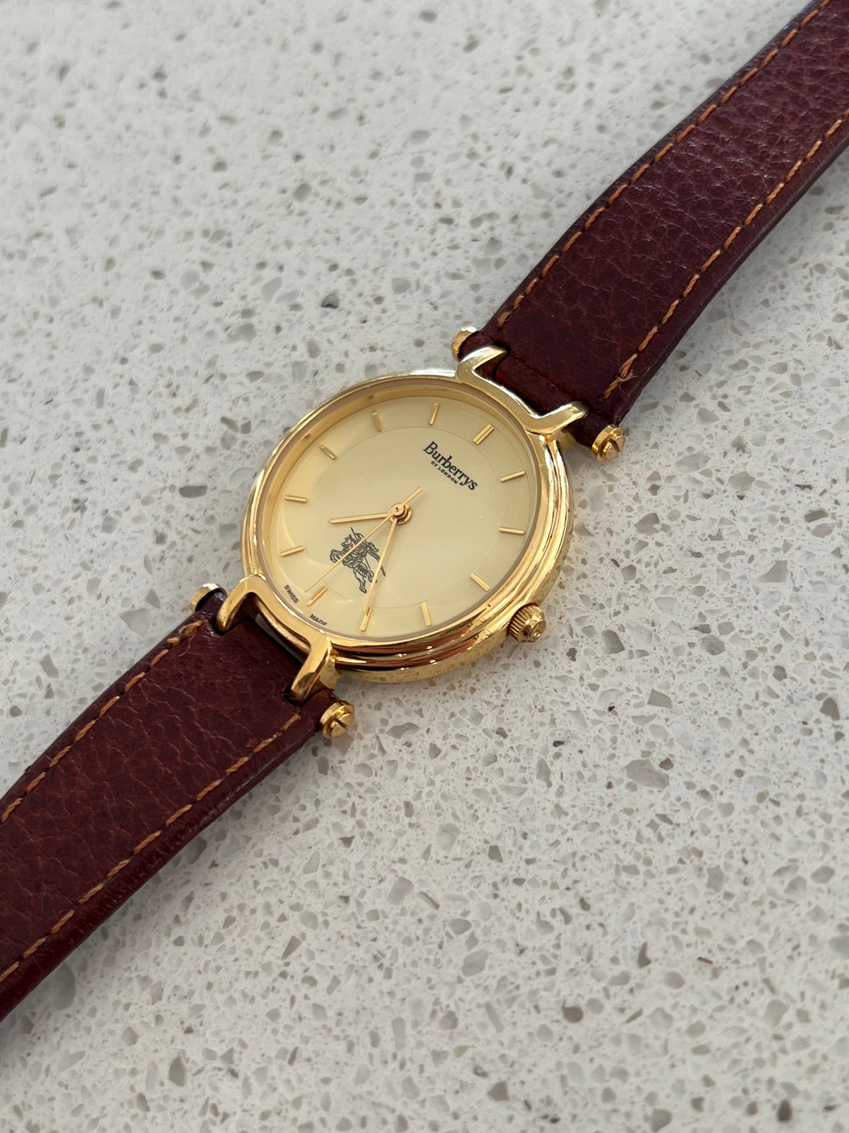 Burberrys gold-tone 32 mm watch shown on a wrist.