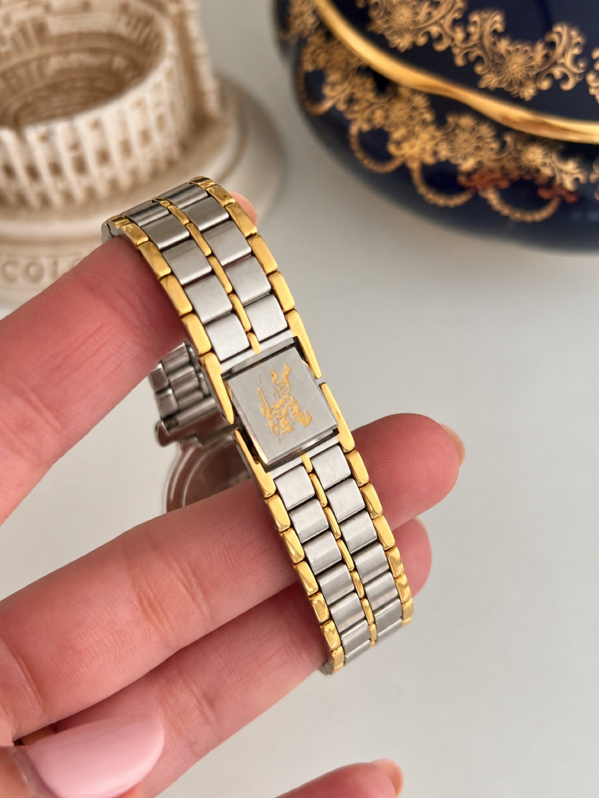 Silver tone Burberrys folding clasp with a gold tone equestrian knight emblem and two tone bracelet.