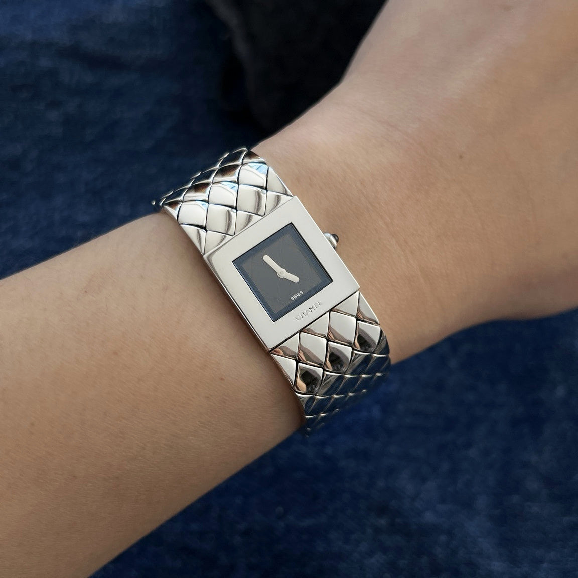 Chanel Matelassé women's watch on a 15 cm wrist, with a black square dial and bright polished quilted steel bracelet