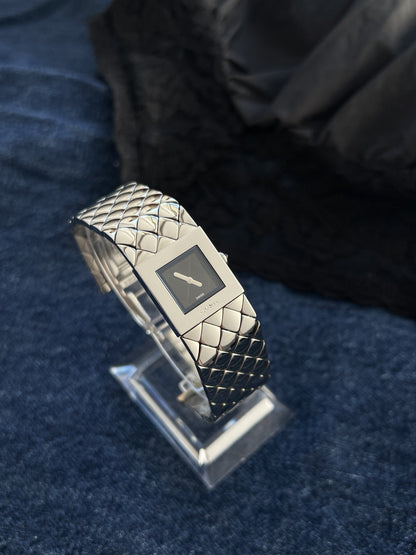 Chanel Matelassé steel bracelet watch displayed against dark navy fabric