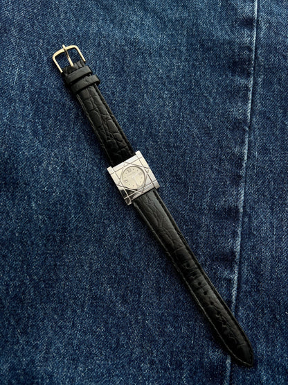 Christian Dior Cannage women’s square steel watch with silver Roman dial and black leather strap arranged on denim