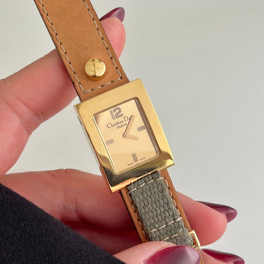 Christian Dior women’s gold square watch on wrist with champagne dial and tan leather strap designer Swiss made