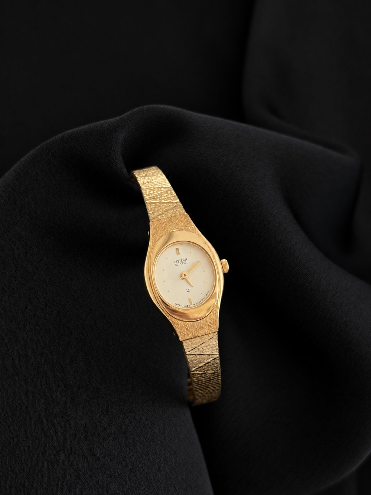 Close front detail of Citizen 5930-S25350 showing the champagne dial, gold-tone bezel and textured bracelet.