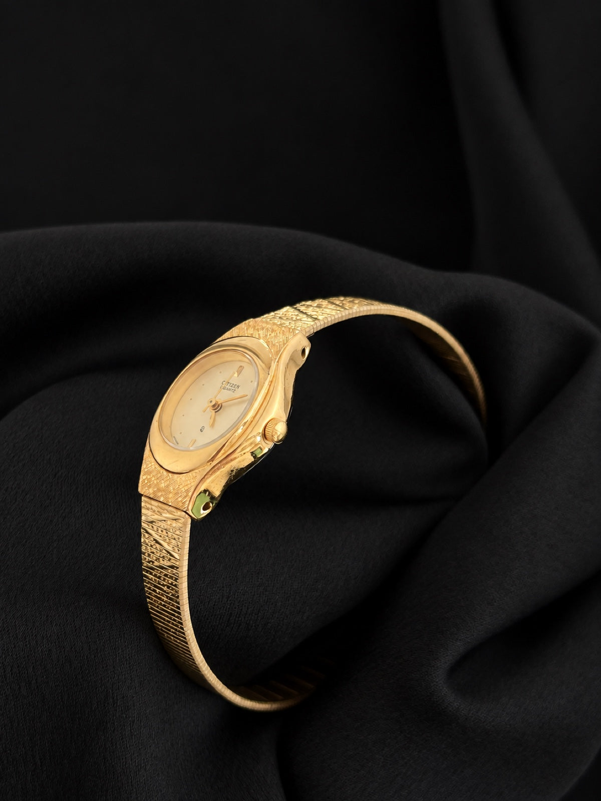 Open bracelet view of the Citizen 5930-S25350 gold-tone watch with oval champagne dial and textured links.