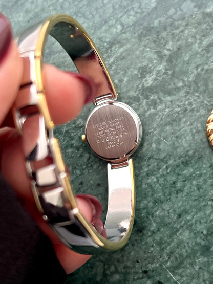 Angled view of the Citizen Chere round case and silver bangle.