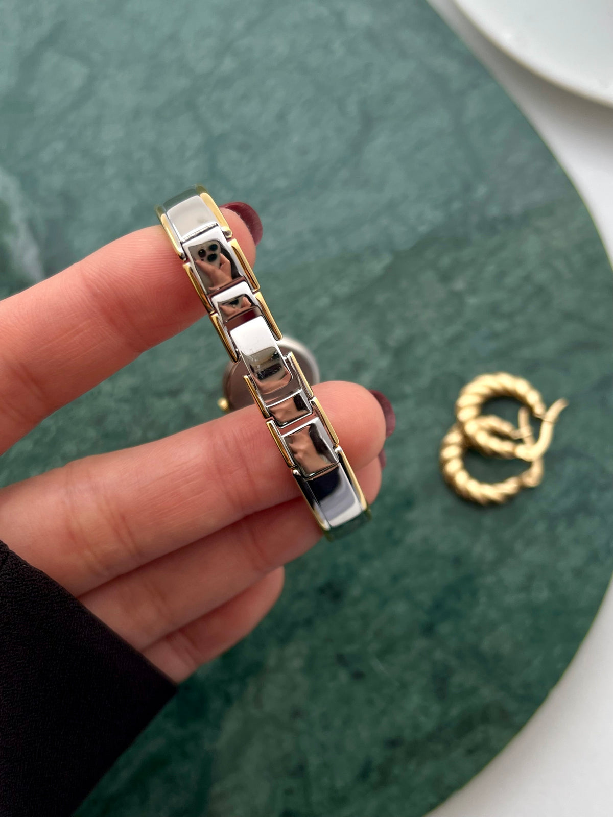 Citizen petite gold and silver bangle watch shown on a wrist.