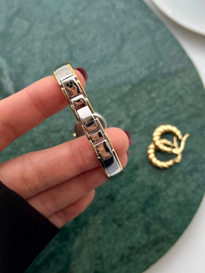 Citizen petite gold and silver bangle watch shown on a wrist.