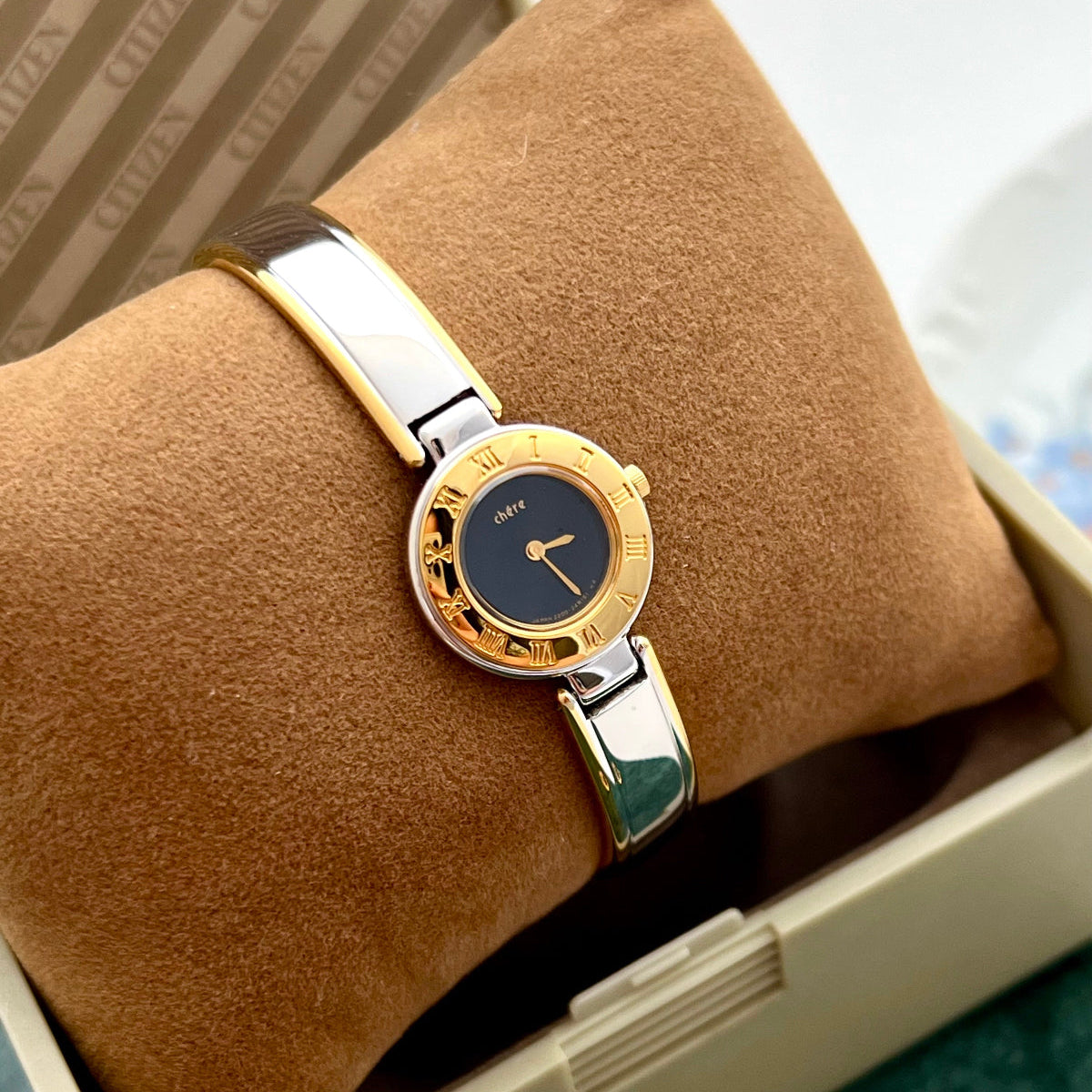Citizen Chere petite gold and silver bangle watch displayed in its box.