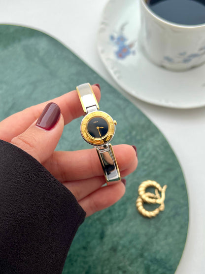 Detail of the polished silver bangle with gold-tone accents.