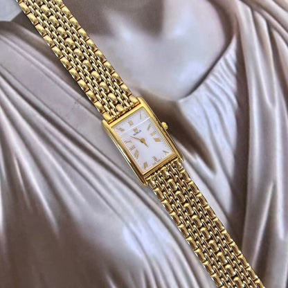 Citizen Noblia women’s watch with Roman numeral dial, small seconds display, rectangular gold tone case and draped jewellery bracelet.