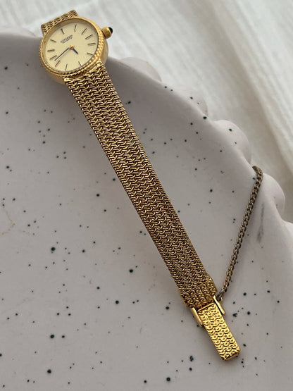 Wrist view of the Citizen ladies watch with its woven gold-tone chain mesh bracelet.