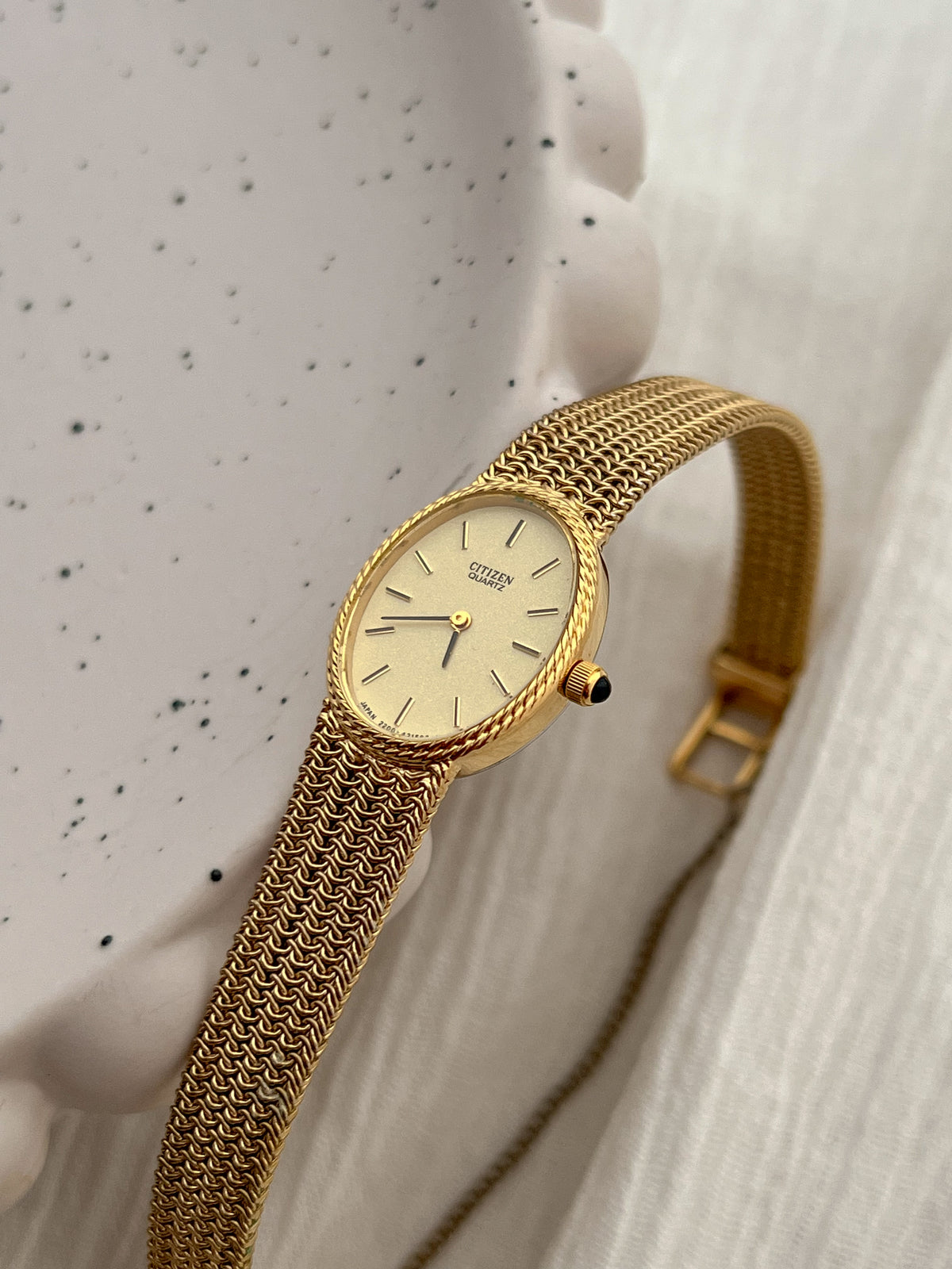 Side profile of the Citizen oval watch case, rope bezel and stone-set crown.