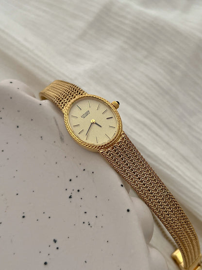 Detail of the Citizen watch's woven gold-tone chain mesh bracelet.