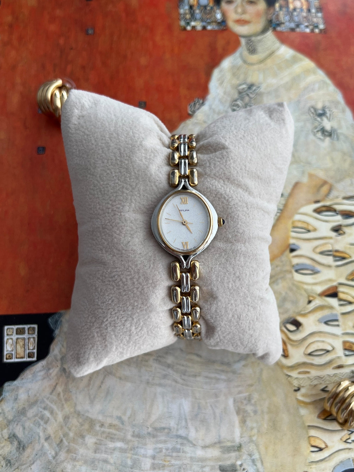 Citizen Sylph women’s watch with a frosted silver oval dial, gold Roman XII and VI, and rounded two tone bracelet