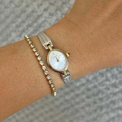 Citizen Sylph oval watch with blue cabochon crown and two-tone bracelet shown on a wrist.