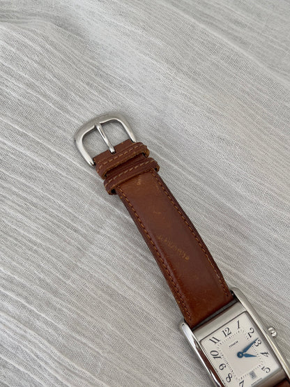 Side profile of the polished rectangular case on a Coach watch.