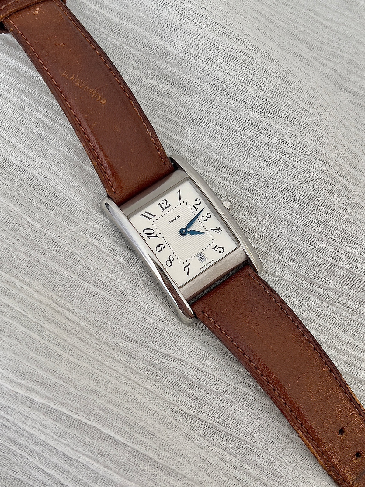 Coach rectangular watch shown on a wrist.