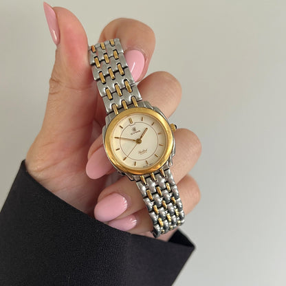 Cyma Sealord cream dial with gold tone baton markers, three hands and a two tone bracelet.