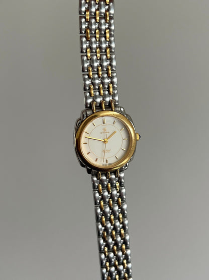 Upright front view of the Cyma Sealord cream dial, gold tone inner circle and full two tone bracelet.