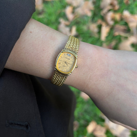 Elgin Gold Glam Woven Bracelet Watch — the gold woven bracelet watch worn on a wrist.