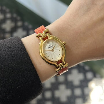 Fendi Chameleon women’s watch on wrist with an oval gold tone case, silver textured dial and red leather strap
