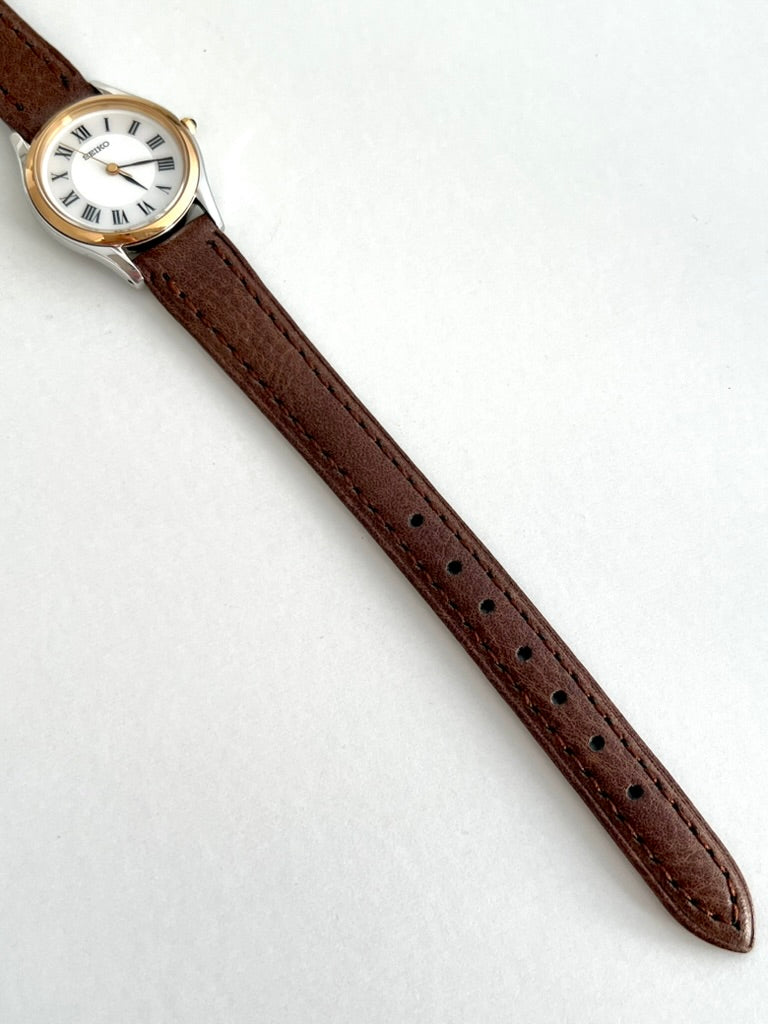 Seiko Exceline brown leather strap showing dark stitching, adjustment holes and rounded strap tip